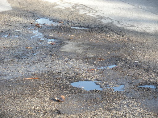 Potholes in an asphalt roadway.